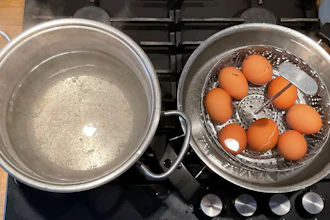 A photo provided by researchers in February 2025 shows two pots, one with boiling water, left, and the other with a basket of eggs in lukewarm water, in a new method of boiling eggs dubbed 'periodic cooking.'