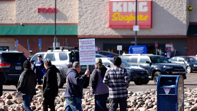 Workers walk a picket line outside a Denver King Soopers store, Feb. 6, 2025.