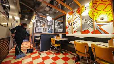 An egg on a mural displaying breakfast items as Teaira Booker sweeps, at The Breakfast Brothers restaurant, Wednesday, Feb. 12, 2025, in Arlington, Texas.