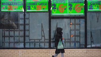 A person walks by a grocery store during a winter storm in Chicago, Feb. 12, 2025.