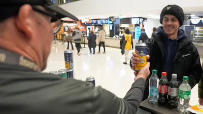 Jimmy Gross serves Jonathon Holdway a Third Space Marquette beer before an NCAA college basketball game, Milwaukee, Feb. 11, 2025.