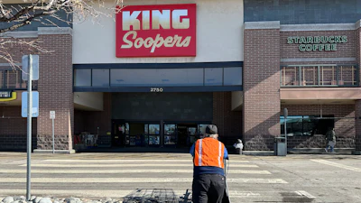 An employee pushes a string of shopping carts back into a King Soopers grocery store, Denver, Jan. 27, 2025.