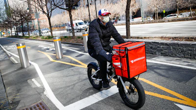 A delivery worker rides his bicycle along a path on the West Side Highway in New York, March 16, 2020.
