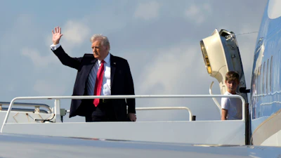 President Donald Trump, left, waves as he boards Air Force One with grandson Theodore, Ivanka Trump's son, at Palm Beach International Airport in West Palm Beach, Fla., Sunday, Feb. 9, 2025.
