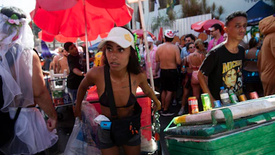 A vendor pulls a cart through a crowd of revelers at the Heaven on Earth pre-Carnival street party, Rio de Janeiro, Feb. 22, 2025.