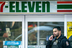 A police officer talks on his phone outside a crime scene at a 7-Eleven in Vancouver, British Columbia, Dec. 4, 2024.