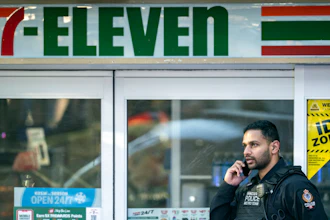 A police officer talks on his phone outside a crime scene at a 7-Eleven in Vancouver, British Columbia, Dec. 4, 2024.