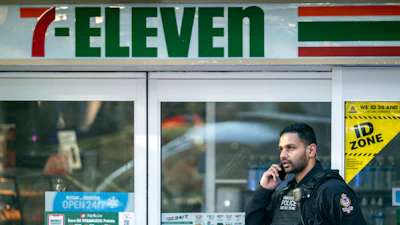 A police officer talks on his phone outside a crime scene at a 7-Eleven in Vancouver, British Columbia, Dec. 4, 2024.