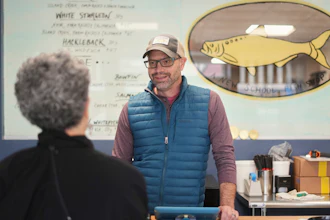 Bryan Szeliga, owner of Fishtown Seafood, speaks with a customer at his shop in Haddonfield, N.J., March 6, 2025.