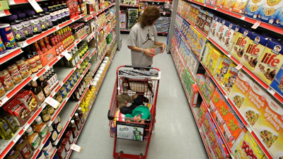 A woman looks at products in the aisle of a store as her daughter naps in the shopping cart in Waco, Texas, on Dec. 14, 2010.