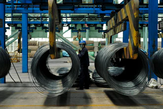 A worker transfers steel cables at a steel factory in Qingdao in east China's Shandong province, June 8, 2018.