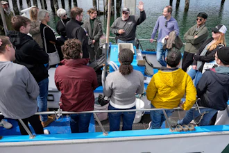 Captain William Smith, with raised hand, talks to people on his boat before departing for a whale watching tour, March 10, 2025, Half Moon Bay, Calif.