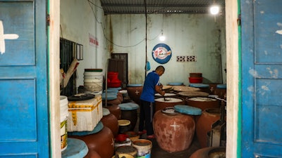 Phan Cong Quang makes fish sauce in his home in Nam O fishing village on March 4, 2025, in Da Nang, Vietnam.