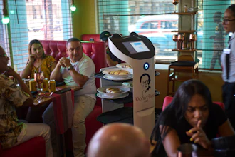 Customers watch as a robot arrives with their food at Dona Alicia restaurant in Havana, April 15, 2025.