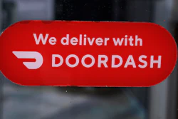 A DoorDash sign posted on the door of a Dunkin' Donuts franchise, Feb. 27, 2023, Methuen, Mass.