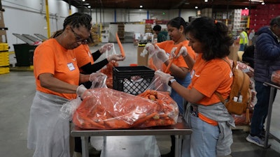 Volunteers pack produce at the Alameda County Community Food Bank in Alameda, Calif., April 25, 2025.