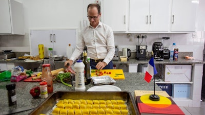Paul-Bertrand Barets, French Ambassador to Zimbabwe, prepares a dish in the kitchen of the residency in Harare, March 16, 2025.