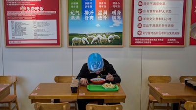Liu Lijie, a food delivery rider from Ele.me, eats a meal at Yushiji restaurant, Beijing, March 18, 2025.