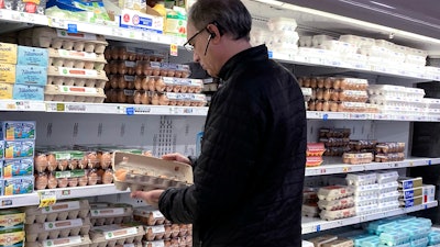 A shopper checks eggs at a grocery store in Glenview, Ill., Jan. 10, 2023.