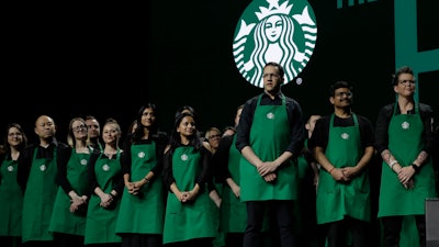 Starbucks baristas stand on stage, March 20, 2019, during an annual shareholders meeting in Seattle.
