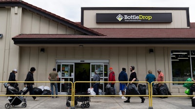 People wait in line outside the Glisan BottleDrop Redemption Center on Thursday, May 15, 2025, in Portland, Ore.