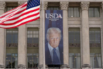 A banner with a photograph of President Donald Trump hangs near the entrance of the U.S. Department of Agriculture building in Washington, Friday, May 16, 2025.