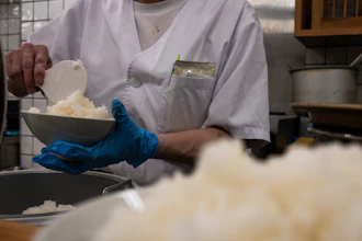 An employee prepares a bowl of rice at a restaurant in Tokyo, Thursday, May 22, 2025.