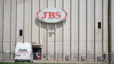 In this Friday, July 223, 2021, photograph, employees move into an entrance to the JBS meat processing plant in Greeley, Colo.