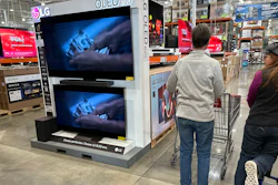 Shoppers pass by televisions on display in a Costco warehouse, Colorado Springs, Colo, Dec. 19, 2024.
