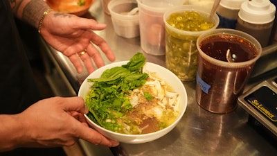 Chef Phila Lorn holds a bowl of the The Mawn Noodle soup at his restaurant, Mawn, in Philadelphia, May 22, 2025.