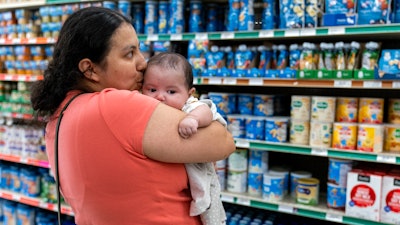 Yury Navas, 29, of Laurel, Md., kisses her two-month-old baby Jose Ismael Gálvez, at Superbest International Market, Laurel, Md., May 23, 2022.