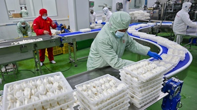 Workers pack dumplings at a production line at a food factory in Suqian city in east China's Jiangsu province on Jan. 21, 2025.