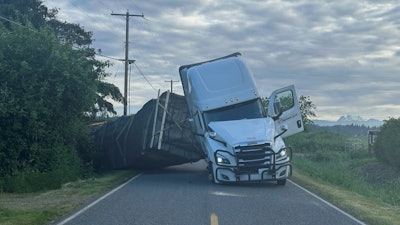 This image taken from video provided by Whatcom County Sheriff's Office shows a truck hauling an estimated 70,000 pounds of honeybee hives overturn on Friday, May 30, 2025 near Lynden, Wash.