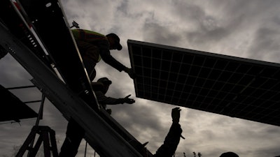 Workers install panels at a solar project Wednesday, May 21, 2025, in Galena, Alaska.