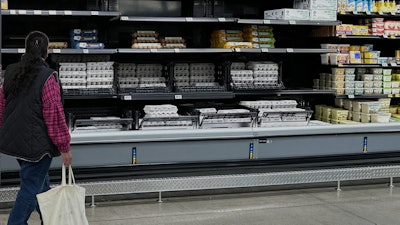 A shopper passes by the display of cartons of eggs in a Walmart store, Feb. 7, 2025, Englewood, Colo.