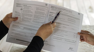 Children's Defense Fund Program Director Graciela Camarena assists Lucia Salazar with filling out Medicaid and SNAP application forms for her family in Pharr, Texas, Nov. 13, 2023.