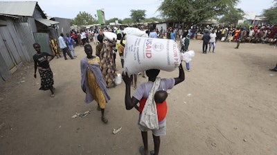 Refugees carry food at a distribution center run by the World Food Programme, Kakuma Refugee Camp, Turkana, Kenya, June 3, 2025.