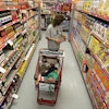 A woman looks at products in the aisle of a store as her daughter naps in the shopping cart in Waco, Texas, Dec. 14, 2010.