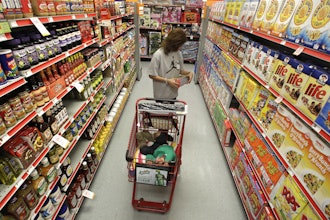 A woman looks at products in the aisle of a store as her daughter naps in the shopping cart in Waco, Texas, Dec. 14, 2010.