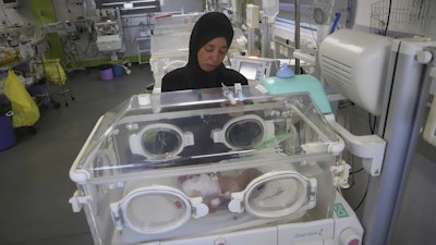 Seham Fawzy Khodeir watches her son, Hisham, in an incubator at the neonatal intensive care unit of Nasser Hospital, Khan Younis, southern Gaza Strip, June 19, 2025.