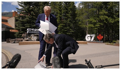 President Donald Trump drops papers as he meets with Britain's Prime Minister Keir Starmer on the sidelines of the G7 Summit, Monday, June 16, 2025, in Kananaskis, Canada.