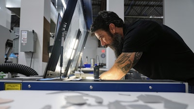 Craig Simile, senior operations manager at Made Plus, prepares materials with a laser cutting machine at the company's manufacturing facility in Annapolis, Md., Tuesday, June 10, 2025.