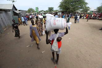 Refugees carry food at a distribution center run by the World Food Programme at Kakuma Refugee Camp in Turkana, Kenya, June 3, 2025.