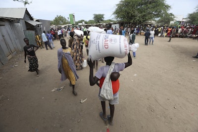 Refugees carry food at a distribution center run by the World Food Programme at Kakuma Refugee Camp in Turkana, Kenya, June 3, 2025.