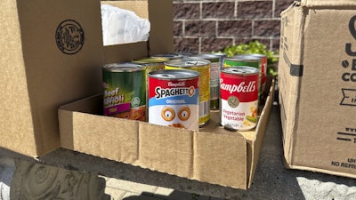 Cans and boxes of food sit on a bench outside the Samaritan Center food pantry in Jefferson City, Mo., July 1, 2025.