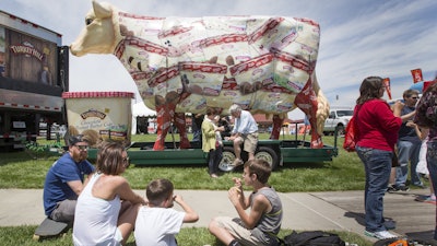 The giant Turkey Hill Cow looms over festival goers sampling ice cream at Taste of Omaha on May 31, 2015, in Omaha, Neb.