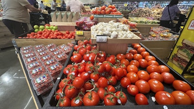 Tomatoes are displayed as customers shop at a grocery store in Glenview, Ill., Tuesday, July 15, 2025.