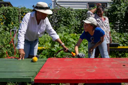 Fany White, right, and Hazel White, family of Alicia White, who is the president and founder of the Project Petals, work at Paradise Community Garden, Friday, Aug. 8, 2025, in Inwood, N.Y.