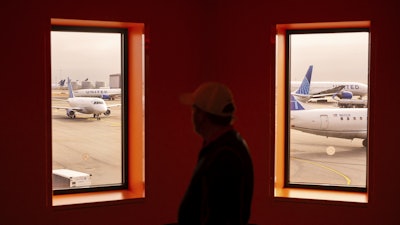 A traveler passes United Airlines planes at San Francisco International Airport on May 8, 2025, in San Francisco.