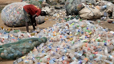 A scavenger sorts out plastic waste at a dumpsite on the outskirts of Lagos, Nigeria, Monday, Aug 11, 2025.